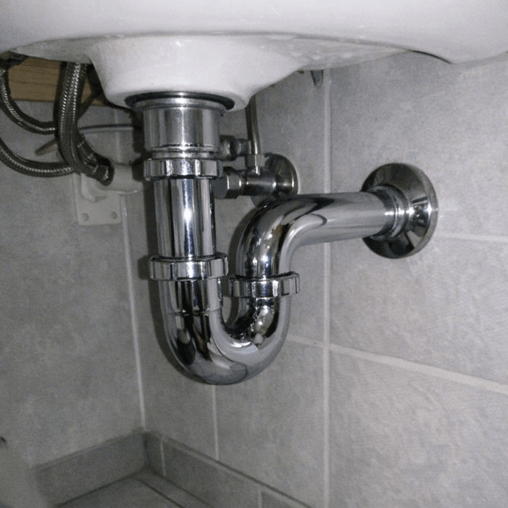 Neu montierter Siphon unter einem weißen Handwaschbecken mit sauber ausgerichteten Rohrverbindungen